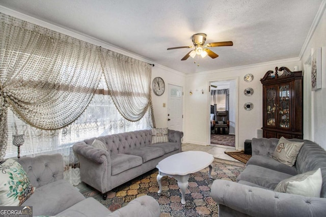 living area featuring tile patterned flooring, ceiling fan, ornamental molding, and a textured ceiling