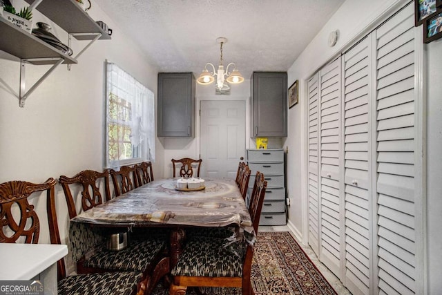 dining space featuring a textured ceiling, breakfast area, and an inviting chandelier