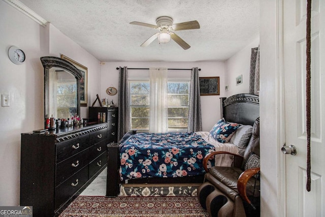 bedroom featuring multiple windows, ceiling fan, and a textured ceiling