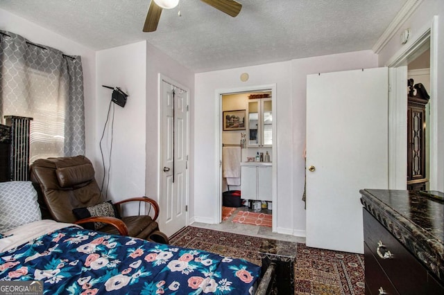 bedroom with a textured ceiling, ensuite bathroom, a ceiling fan, and baseboards