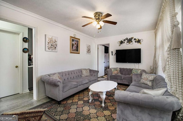 living room featuring a textured ceiling, ceiling fan, and ornamental molding