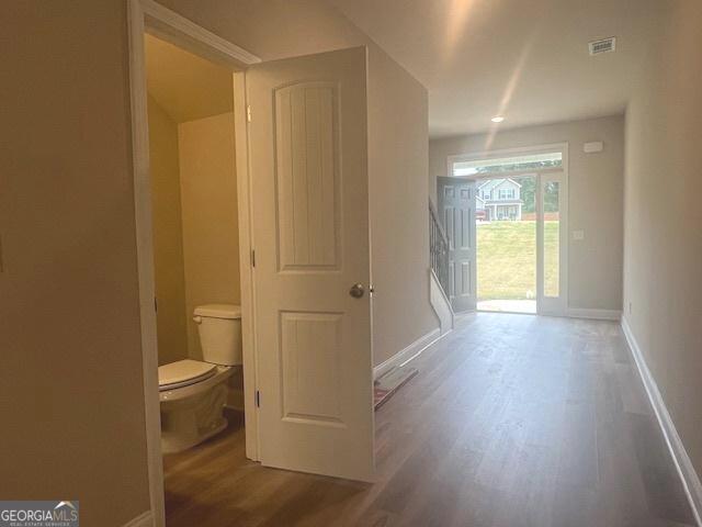 bathroom featuring visible vents, toilet, baseboards, and wood finished floors