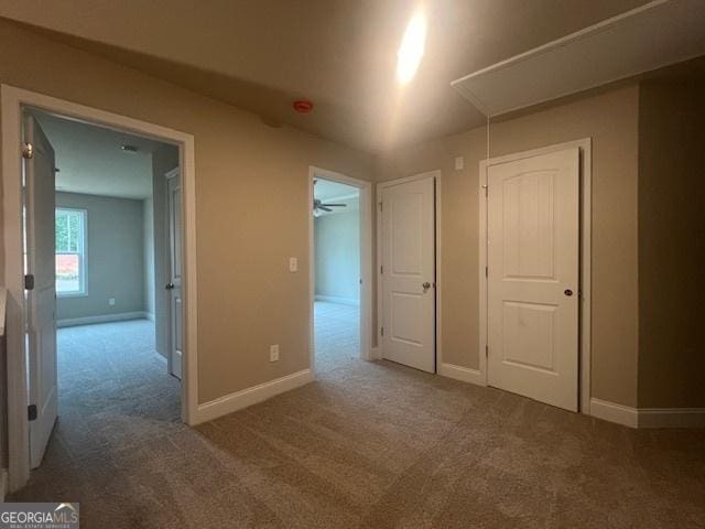 unfurnished bedroom with carpet floors, attic access, and baseboards