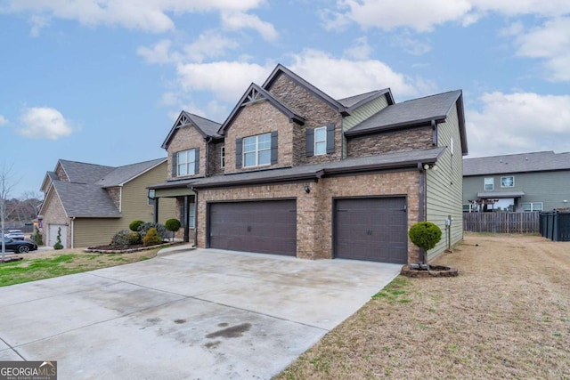 view of front facade featuring a garage, brick siding, driveway, and fence