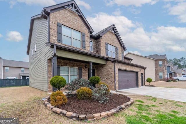 view of front facade with an attached garage, brick siding, fence, driveway, and a front yard