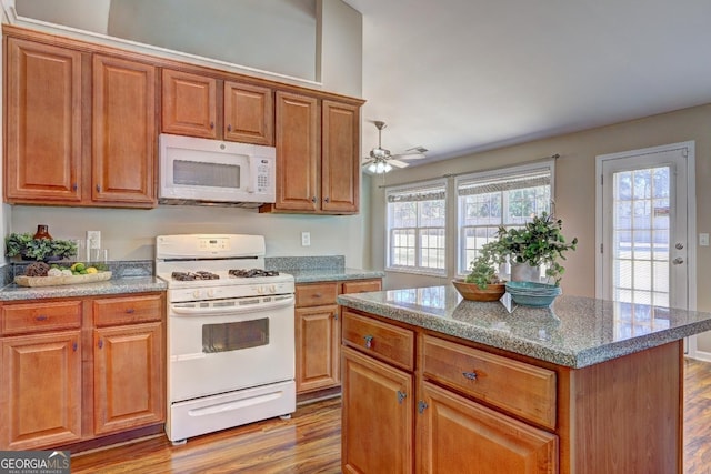 kitchen featuring white appliances and brown cabinetry