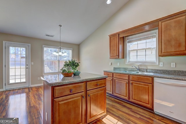 kitchen with decorative light fixtures, visible vents, vaulted ceiling, white dishwasher, and a sink