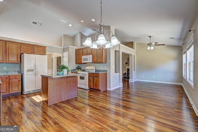 kitchen with white appliances, a kitchen island, brown cabinets, decorative light fixtures, and vaulted ceiling