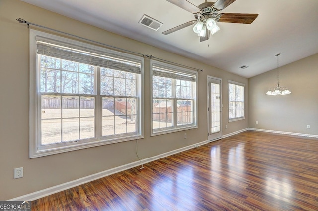 empty room featuring lofted ceiling, dark wood-type flooring, visible vents, and baseboards