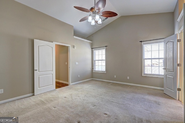 unfurnished bedroom featuring high vaulted ceiling, light carpet, baseboards, and a ceiling fan