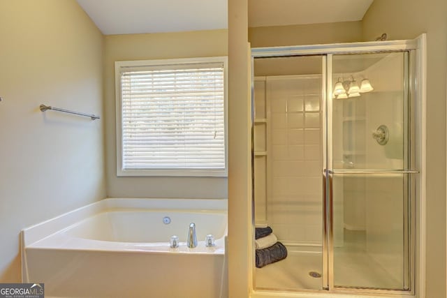 full bathroom with a shower stall and a bath