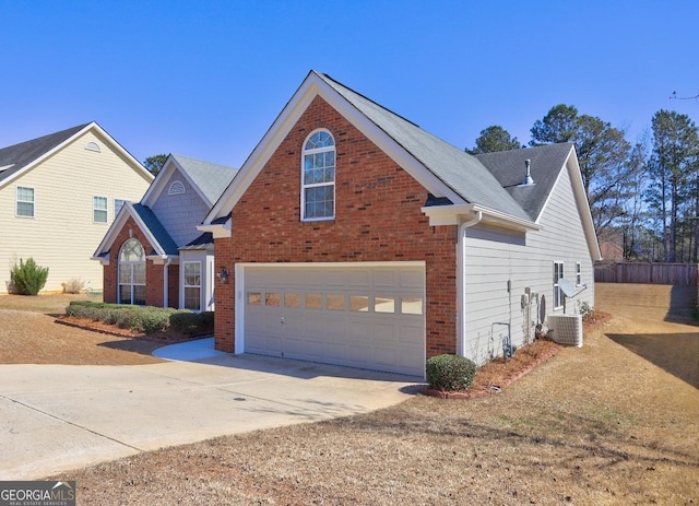 traditional home with an attached garage, cooling unit, concrete driveway, and brick siding