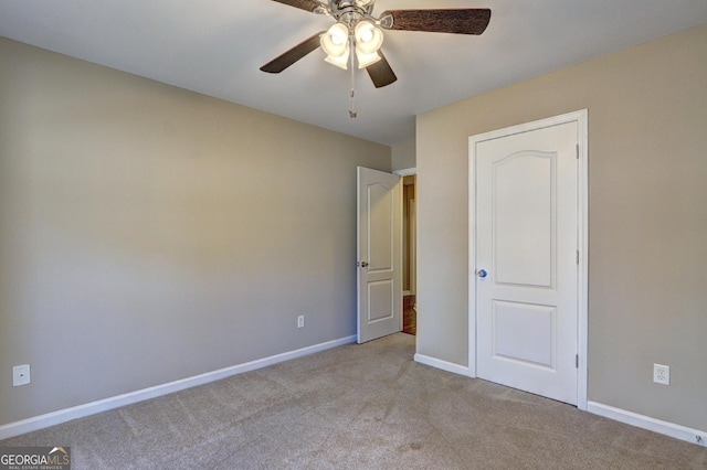 unfurnished bedroom with light colored carpet, ceiling fan, and baseboards