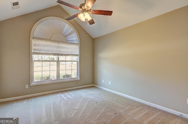 spare room with baseboards, visible vents, a ceiling fan, light colored carpet, and lofted ceiling