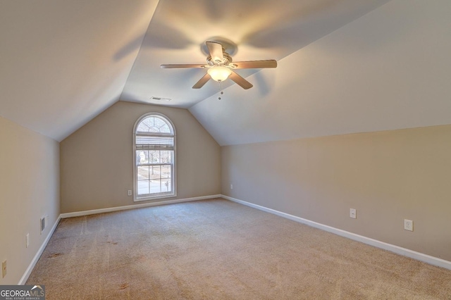 additional living space featuring lofted ceiling, visible vents, light carpet, and baseboards