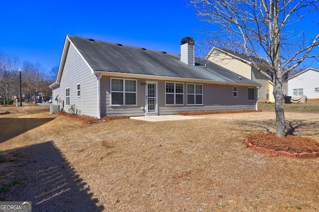 rear view of property featuring a patio area, a chimney, and central AC unit