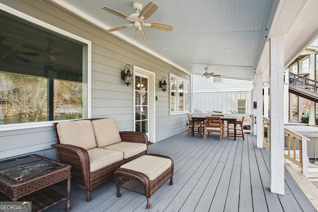 wooden deck featuring outdoor dining area, ceiling fan, and an outdoor living space