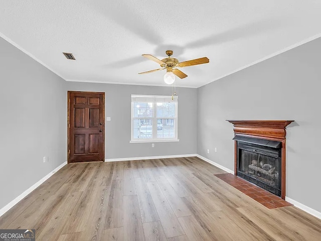 unfurnished living room featuring visible vents, a textured ceiling, light wood-style flooring, and baseboards