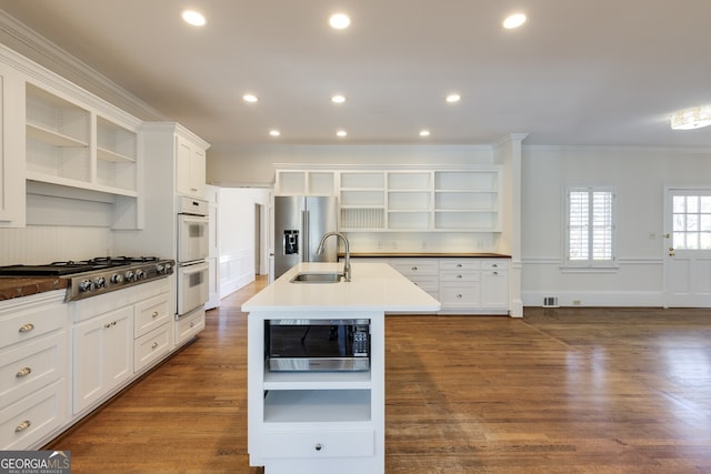 kitchen featuring stainless steel appliances, a sink, white cabinetry, open shelves, and a center island with sink