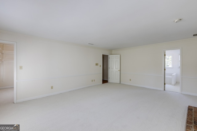 empty room featuring light carpet, baseboards, visible vents, and crown molding