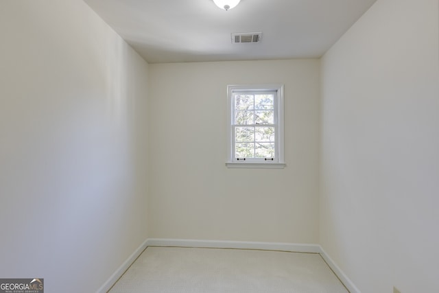 spare room with light carpet, baseboards, and visible vents