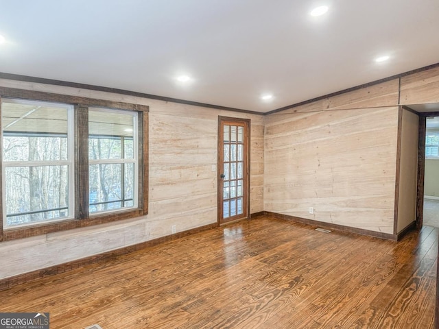 unfurnished room with recessed lighting, crown molding, baseboards, and wood finished floors