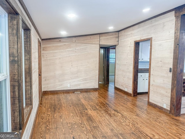 unfurnished room featuring wood walls and wood finished floors