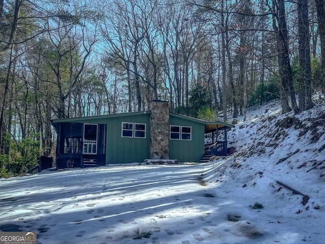 view of front of home with a sunroom and a chimney