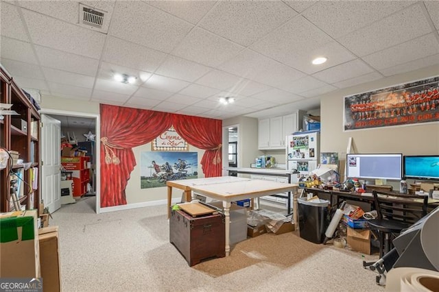 office space featuring a paneled ceiling, carpet, visible vents, and baseboards