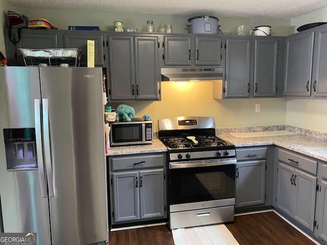 kitchen featuring gray cabinetry, light countertops, appliances with stainless steel finishes, and under cabinet range hood