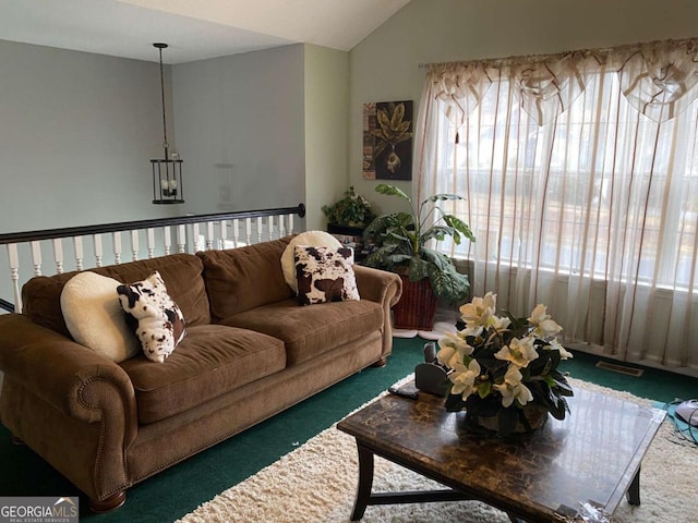 living room featuring lofted ceiling, visible vents, and dark carpet