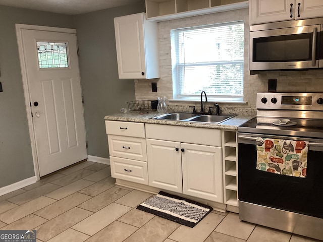 1141 N Clark St, Milledgeville, GA 31061 - kitchen featuring white cabinets, decorative backsplash, stainless steel appliances, light countertops, and a sink