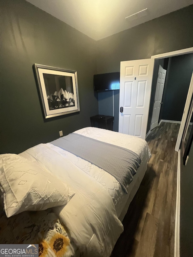 bedroom featuring vaulted ceiling and dark wood-type flooring