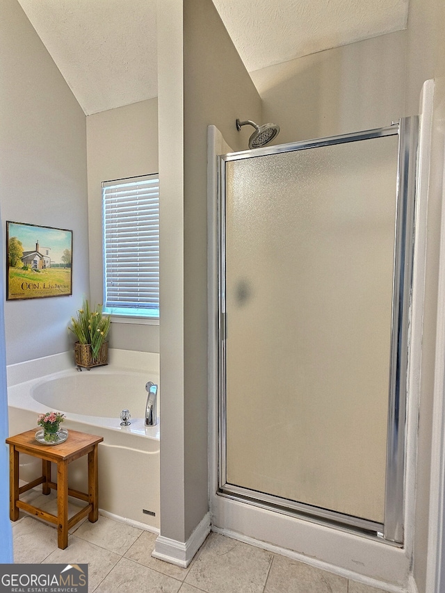 bathroom with a stall shower, a textured ceiling, and tile patterned floors