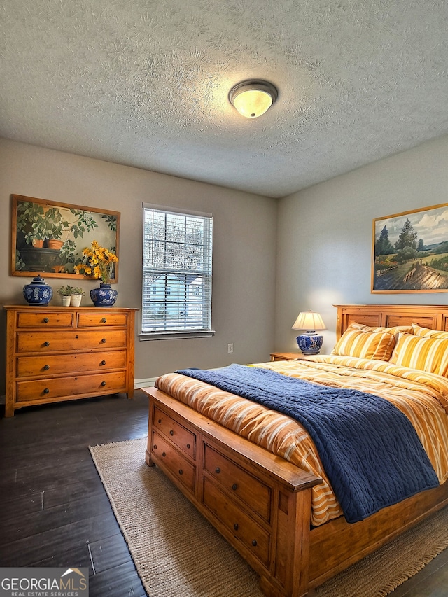 bedroom with dark wood finished floors and a textured ceiling