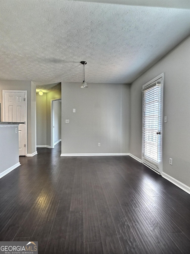 unfurnished living room featuring a textured ceiling, baseboards, and dark wood-style flooring