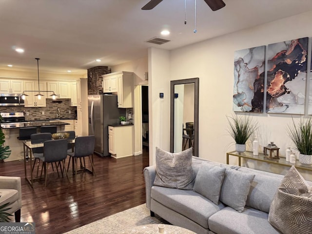 living room featuring ceiling fan, visible vents, dark wood-style flooring, and recessed lighting