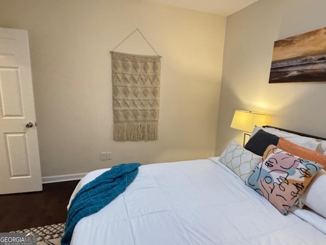 bedroom with baseboards and wood finished floors