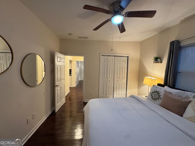 bedroom featuring baseboards, visible vents, dark wood finished floors, and a closet