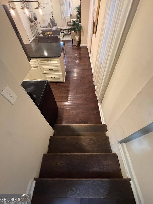 staircase with baseboards and wood finished floors