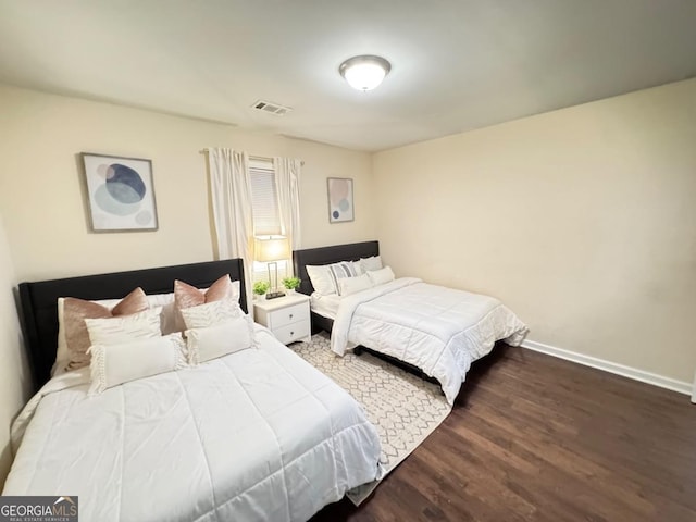 bedroom featuring baseboards, visible vents, and wood finished floors