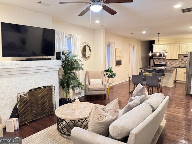 living area with visible vents, baseboards, a ceiling fan, and dark wood-style floors