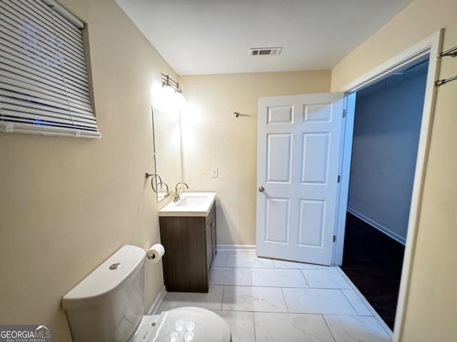 bathroom with vanity, baseboards, toilet, visible vents, and marble finish floor