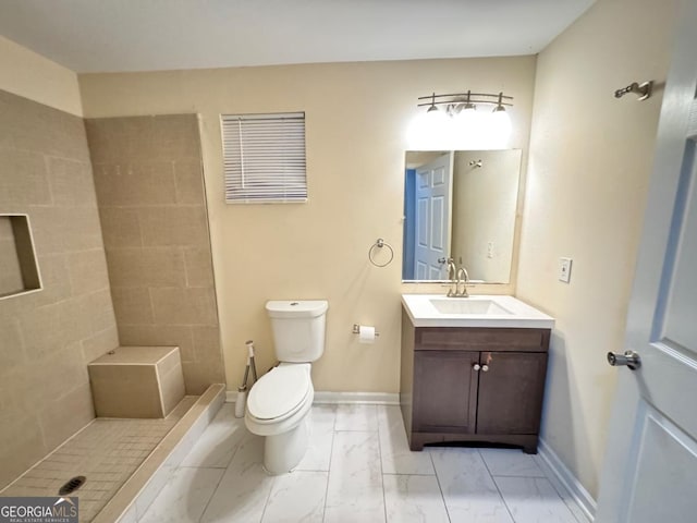 bathroom featuring marble finish floor, vanity, toilet, and baseboards