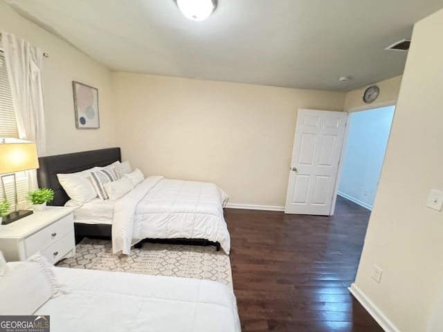 bedroom featuring visible vents, baseboards, and wood finished floors