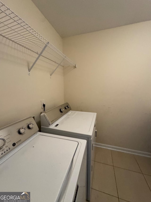 laundry room featuring baseboards, tile patterned flooring, laundry area, and washing machine and clothes dryer