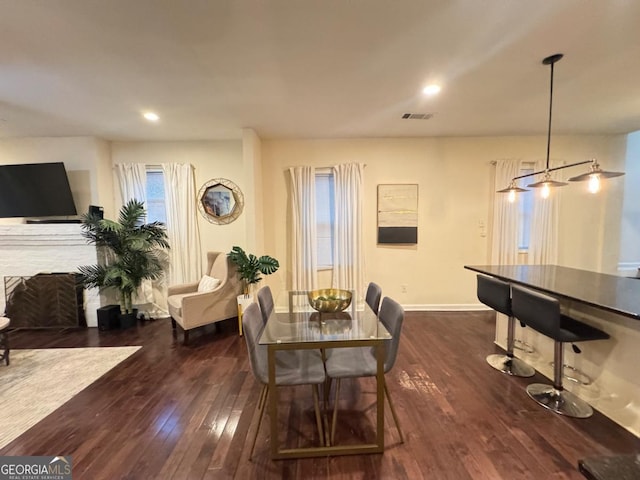 dining space with recessed lighting, dark wood finished floors, visible vents, and baseboards