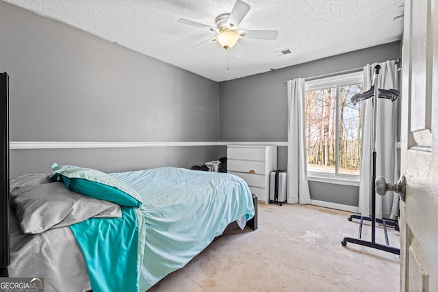 bedroom with baseboards, ceiling fan, visible vents, and a textured ceiling