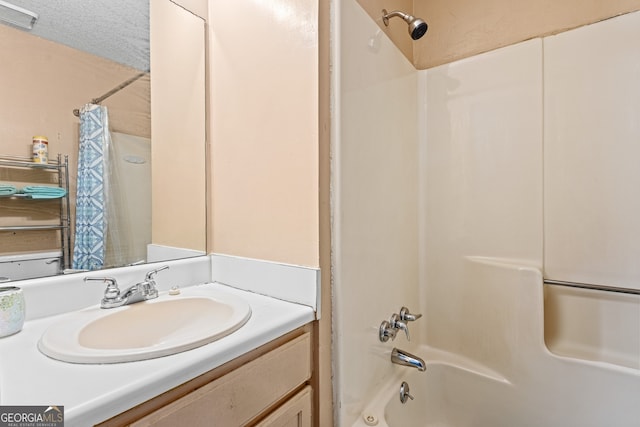 full bath featuring a textured ceiling, vanity, and shower / bathtub combination with curtain