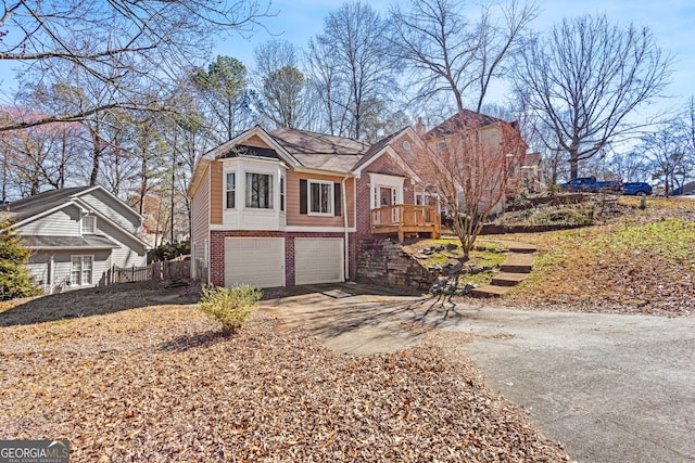 view of front of house featuring a deck, driveway, brick siding, and an attached garage